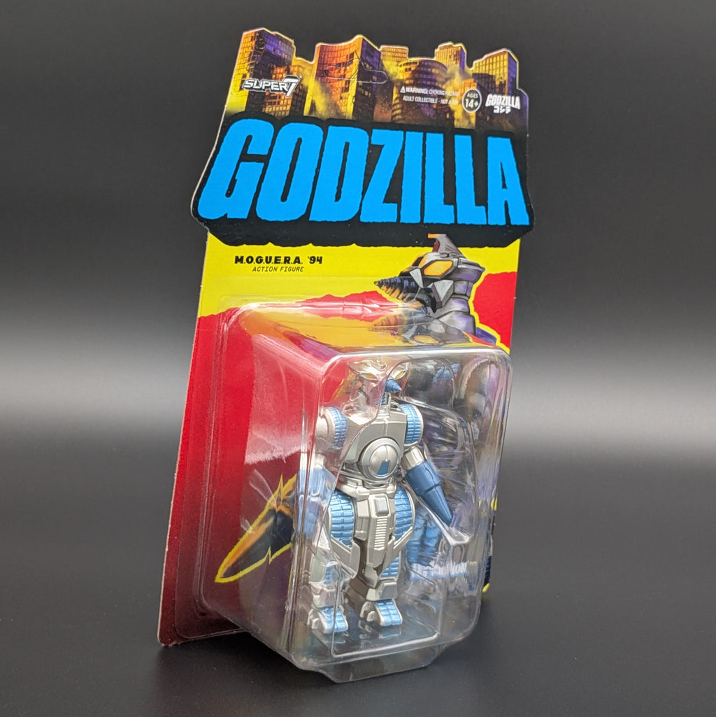 A packaged Godzilla Moguera '94 action figure in a clear blister pack with a colorful cardback. The cardback features a large blue 'GODZILLA' logo, a yellow band, and red lower sections, with the figure visible inside.