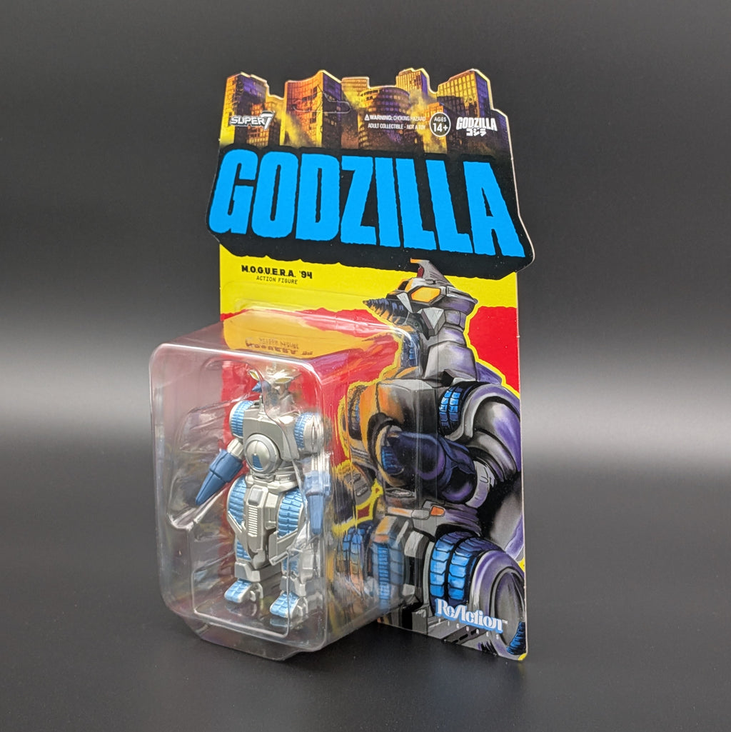 Godzilla Mogeura '94 action figure in its original packaging, featuring a silver and blue robot figure inside a clear blister pack with a colorful cardback.