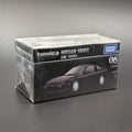 A boxed Tomica Nissan 180SX model car package on a dark gray background. The box is mostly black with white text and a printed photo of a  coupe car.