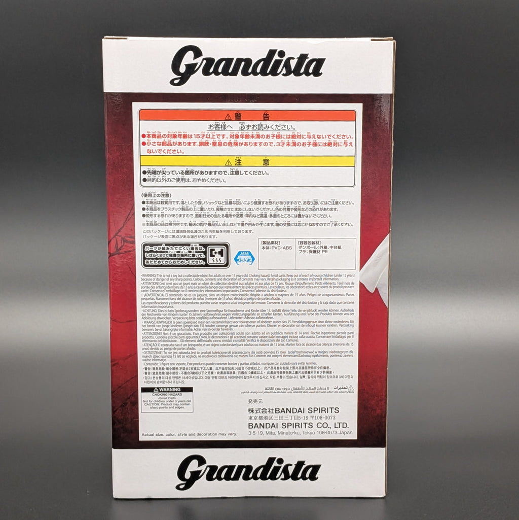 The back of a Grandista model box, showing Japanese text, specifications, and warning labels, photographed against a dark gray background.