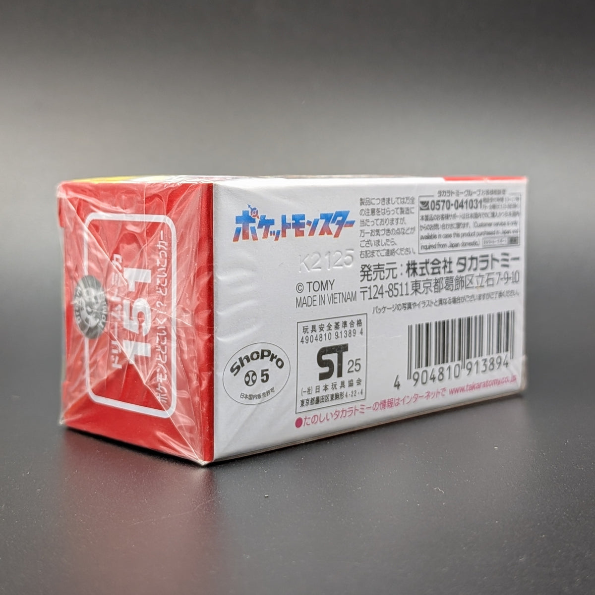 A white and red package, placed on a dark grey background.  Japanese writing and the number 151 can be seen on the sides of the box.