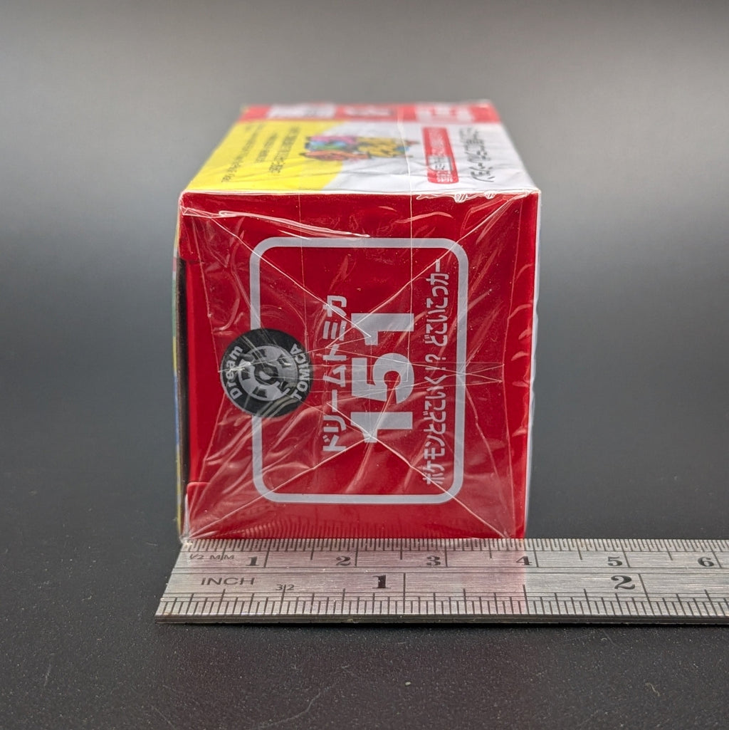 A red and white box with the number 151 printed on the side, sits on a grey background against a ruler shown for scale.