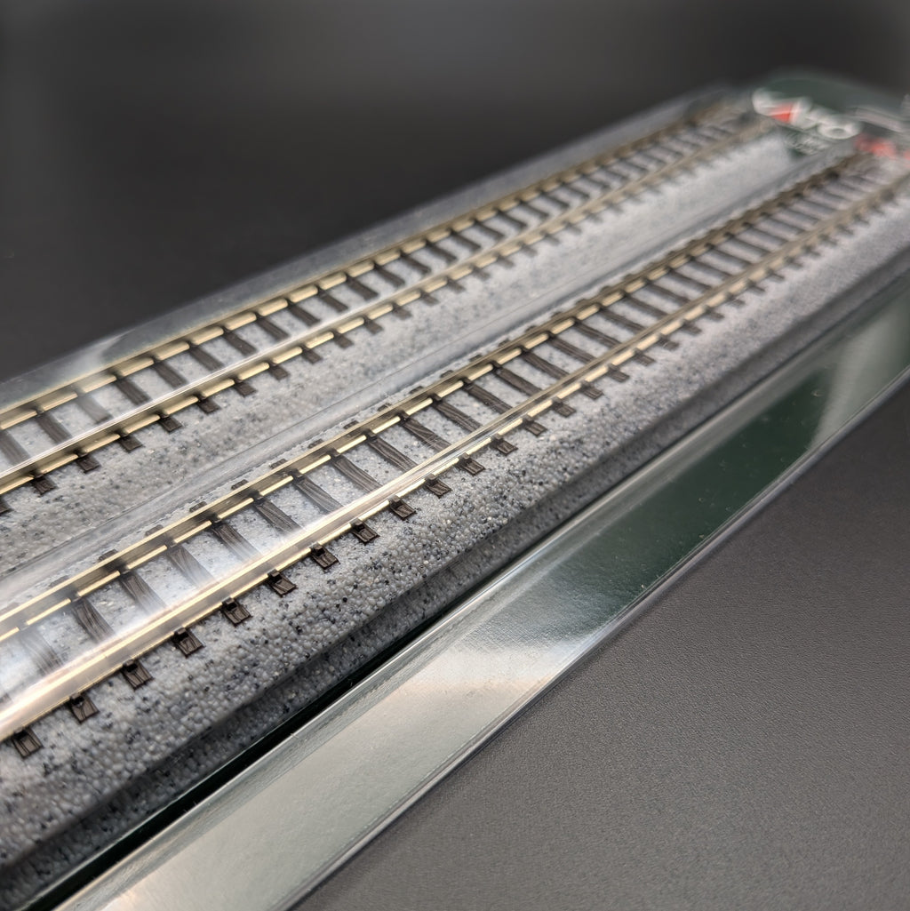 Kato Unitrack 20-010 S186 — Straight Track, N-gauge (Pack of 4). A close-up of the track, through the clear outer packaging to show the finish and texture. Displayed on a black background.