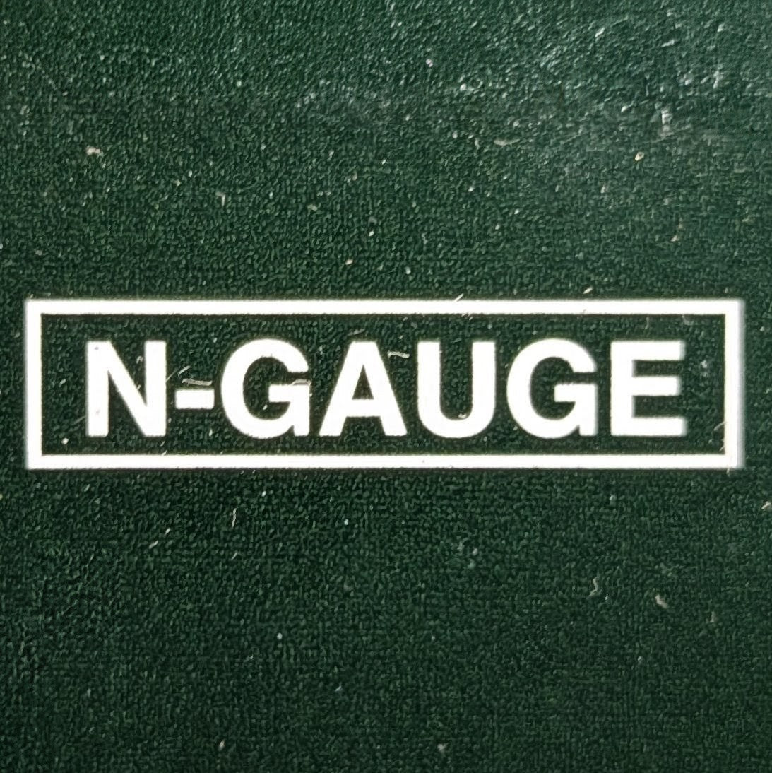 A white bold 'N-GAUGE' sign on a green back background that looks like fake grass.