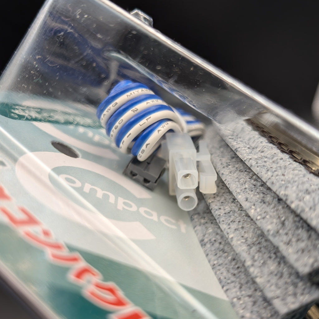Kato CV1 Unitrack Compact Complete Track Set (model 20-890) in its original packaging. A close-up of a compact coil of blue and white wire, with one white and one grey plastic connector.