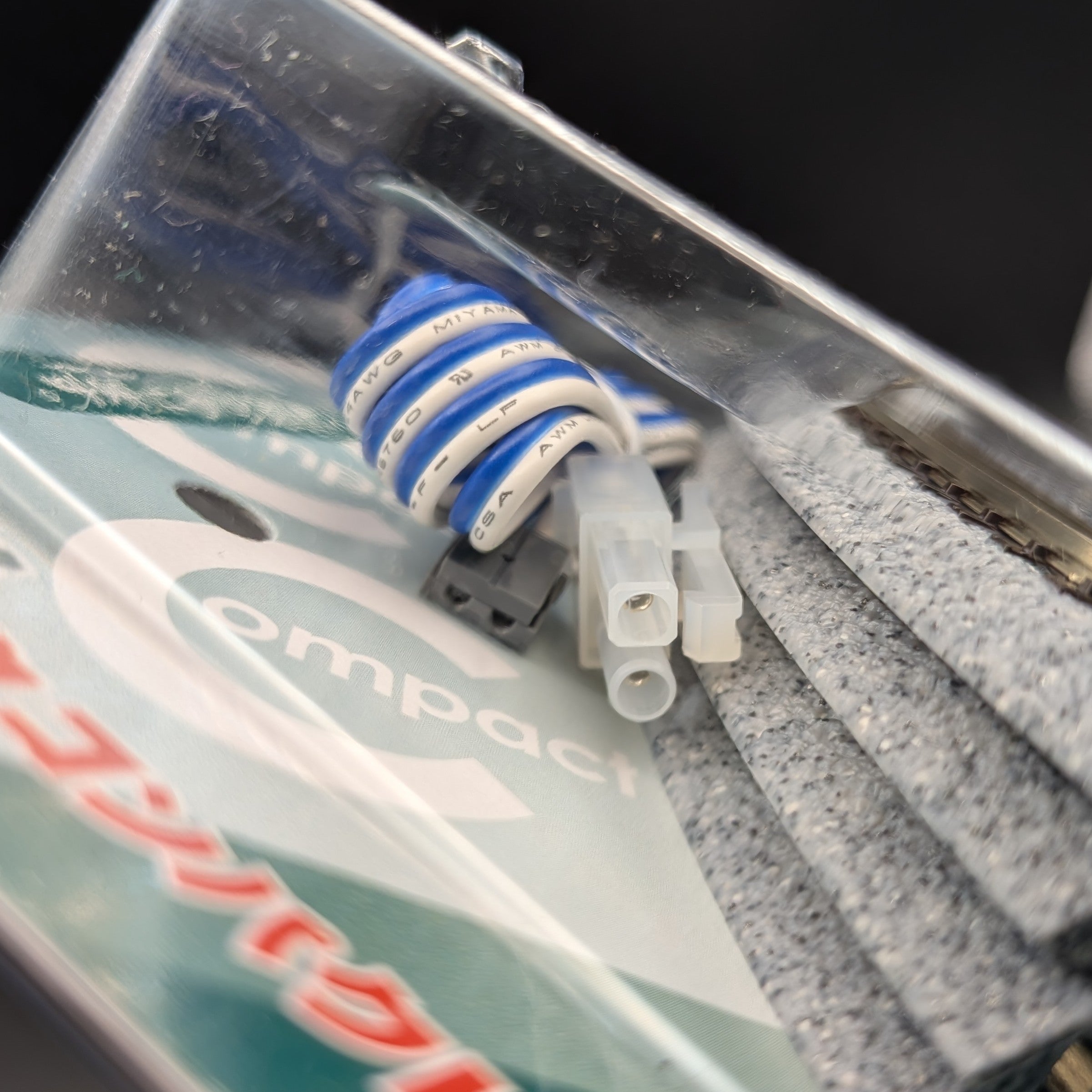 Kato CV1 Unitrack Compact Complete Track Set (model 20-890) in its original packaging. A close-up of a compact coil of blue and white wire, with one white and one grey plastic connector.