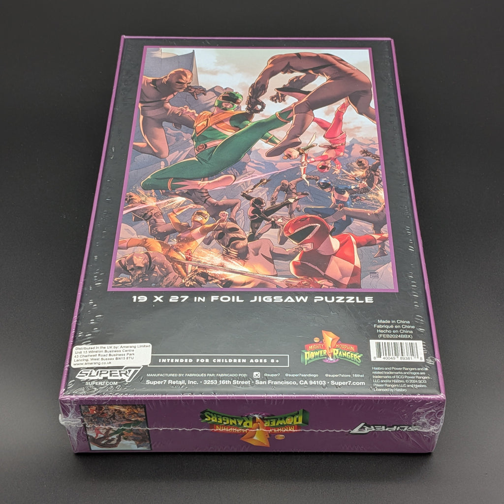 Super7 Power Rangers foil jigsaw puzzle box, sealed in plastic shrink wrap, photographed on a dark gray background.