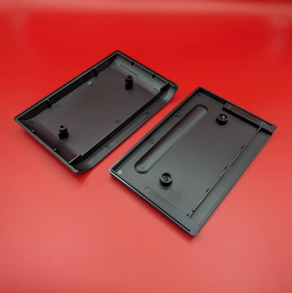 Inside of a black plastic video game cartridge shown on a solid red background.