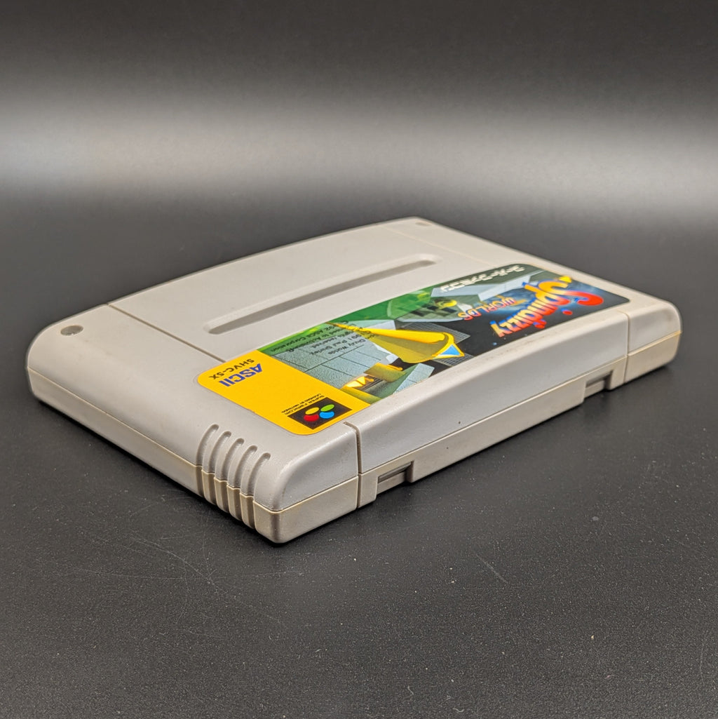 Spindizzy Worlds video game cartridge for Nintendo's Super Famicom (SFC) Entertainment System, shown laying on its back with the label facing upwards. Showing the right hand side and top edge. It sits on a dark grey background.