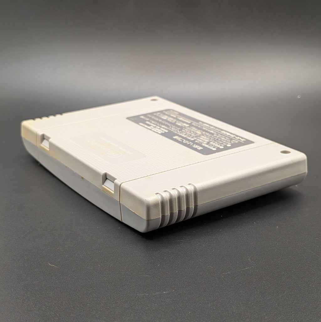 Street Fighter 2 Turbo: Hyper Fighting video game cartridge for the Super Famicom Entertainment System, shown laying on its front, at a 3/4 angle facing down so the back label is visible. Pictured on a dark grey background.