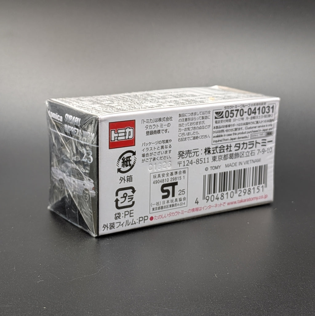 A Takara Tomy model car sealed in its packaging, with japanese writing, sat on a dark grey background.