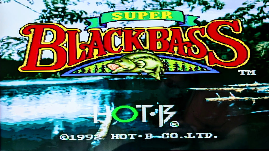 Digital title screen for Nintendo's 'Super Black Bass' for the super famicom, featuring a large red and yellow title logo over a lake scene with a bass fish graphic, and 'HOT-B' branding at the bottom.