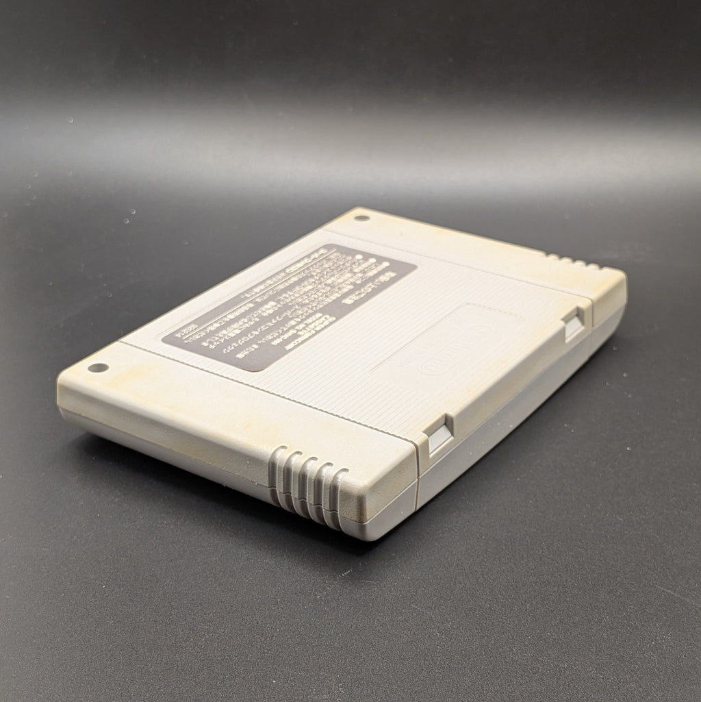 Super Black Bass video game cartridge for Nintendo's Super Famicom (SFC) Entertainment System, shown laying on its front, back label and logo visible at a 3/4 view, on a dark grey background.