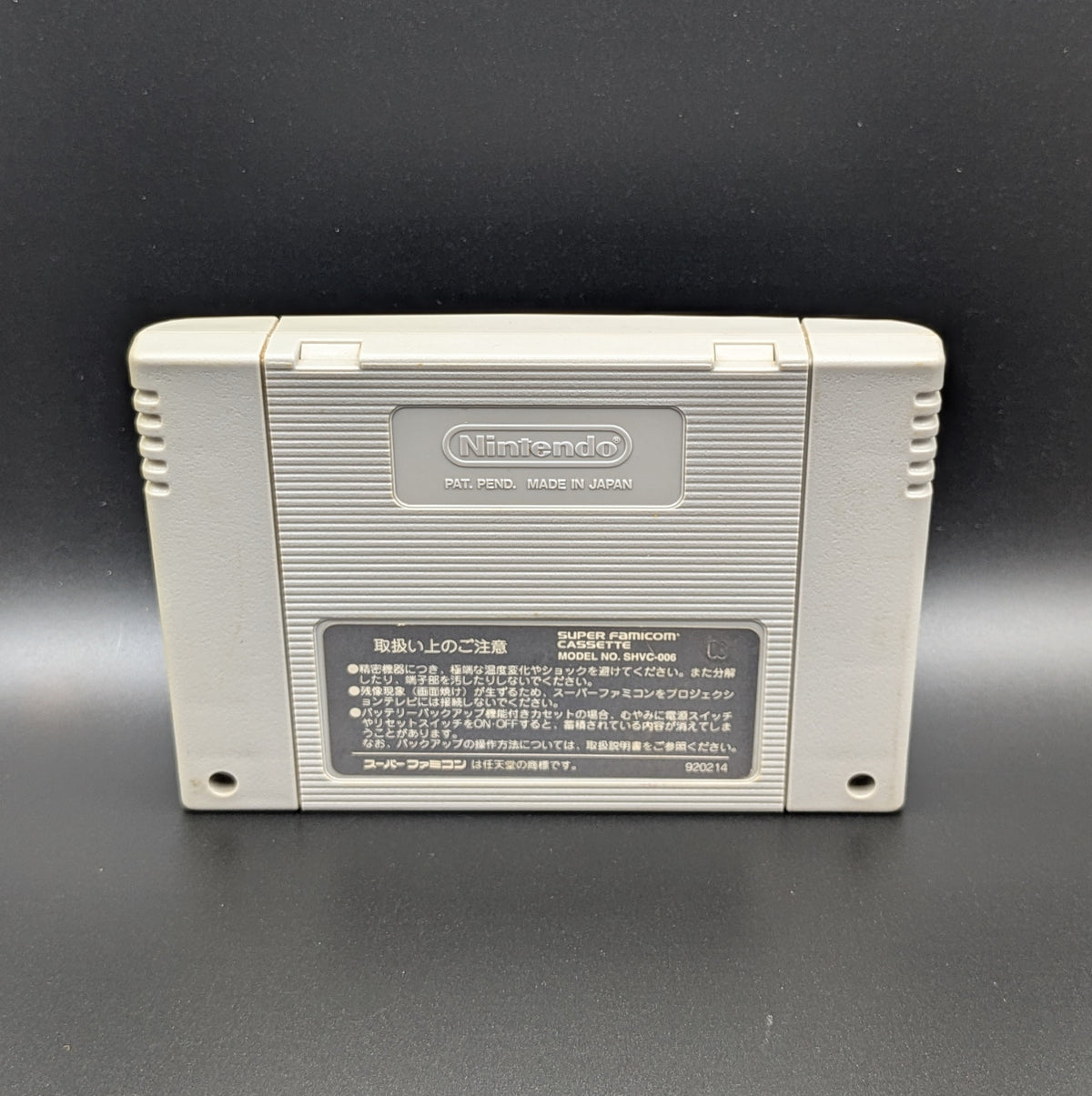 Super Bomberman 3 video game cartridge for Nintendo's Super Famicom (SFC) Entertainment System, showing the back of the cartridge. It sits on a dark grey background.