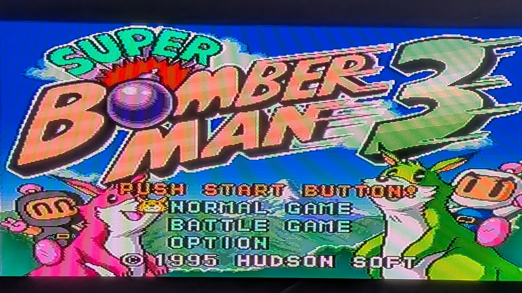 Vintage video game title screen for Super Bomber Man 3, showing colourful retro text and illustrated characters on a bright blue background. Visible text includes 'SUPER BOMBER MAN 3', '1995 HUDSON SOFT'. Released by Nintendo for the Super Famicom (SFC).