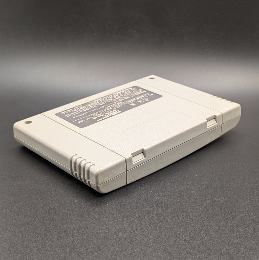Super Bomberman 4 video game cartridge for Nintendo's Super Famicom (SFC) Entertainment System, shown laying on its back, showing the back label. It sits on a dark grey background.
