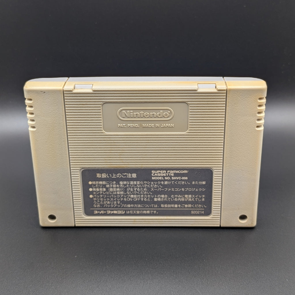 Super Bomberman video game cartridge for Nintendo's Super Famicom (SFC) Entertainment System, showing the back of the cartridge. It sits on a dark grey background.