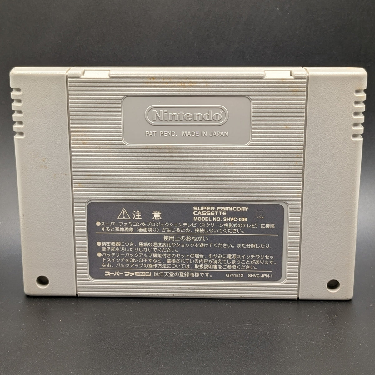 Super Donkey Kong 3 video game cartridge for Nintendo's Super Famicom (SFC) Entertainment System, shown from the back, standing up on a dark grey background. The back label and Nintendo logo are visible.
