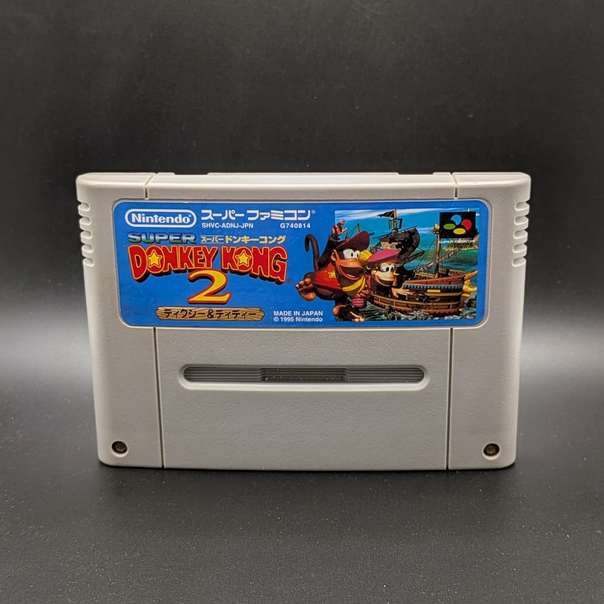 Donkey Kong 2 video game cartridge for Nintendo's Super Famicom (SFC) Entertainment System, shown standing up and facing forward on a dark grey background.
