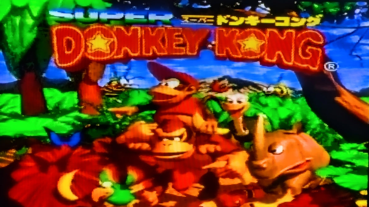 The digital game title screen for Nintendo's Super Donkey Kong for the Super Famicom (SFC), featuring Donkey Kong, Diddy Kong, and other characters under a large glowing 'DONKEY KONG' title on a colorful jungle background.
