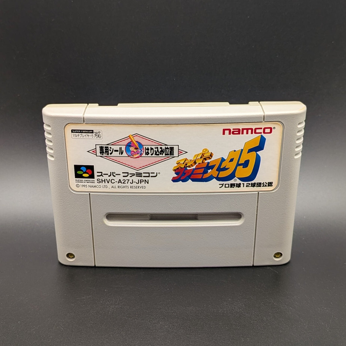 Super Famista 5 video game cartridge for Nintendo's Super Famicom (SFC) Entertainment System, shown standing up and facing forward on a dark grey background.