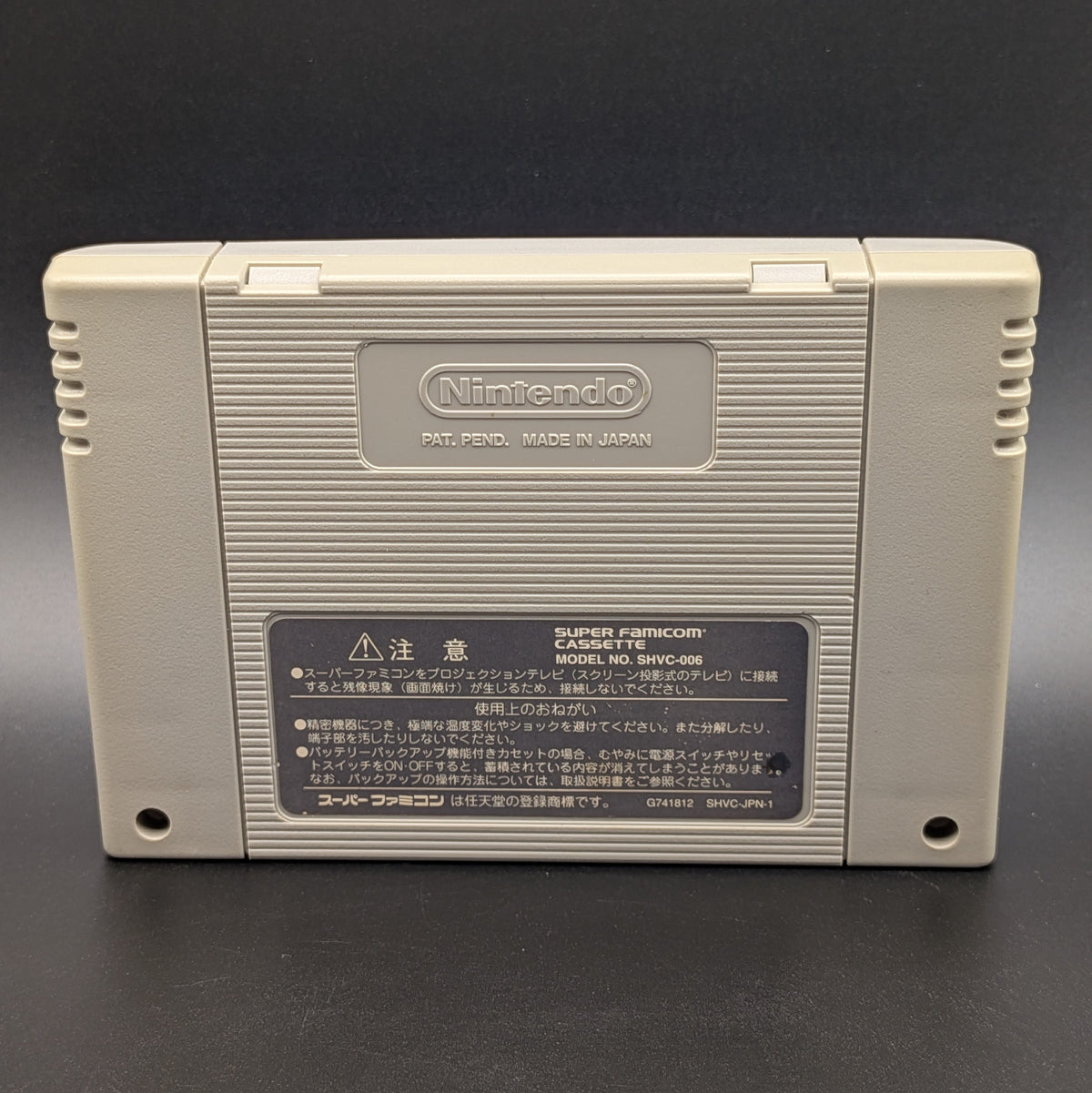 Super Famista 5 video game cartridge for Nintendo's Super Famicom (SFC) Entertainment System, showing the back of the cartridge. The back panel has started to yellow slightly and It sits on a dark grey background.