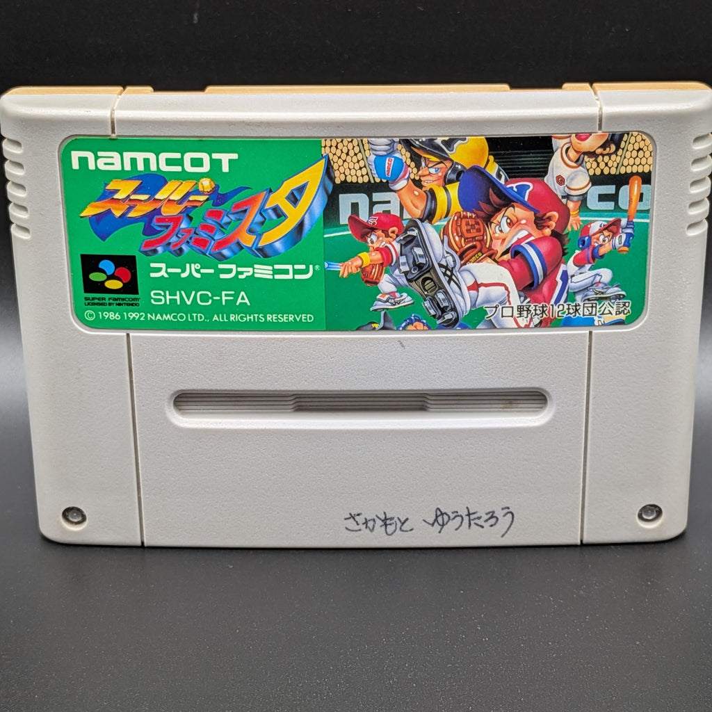 A close up of Super Famista video game cartridge for Nintendo's Super Famicom (SFC) Entertainment System, shown standing up and facing forwards on a dark grey background.