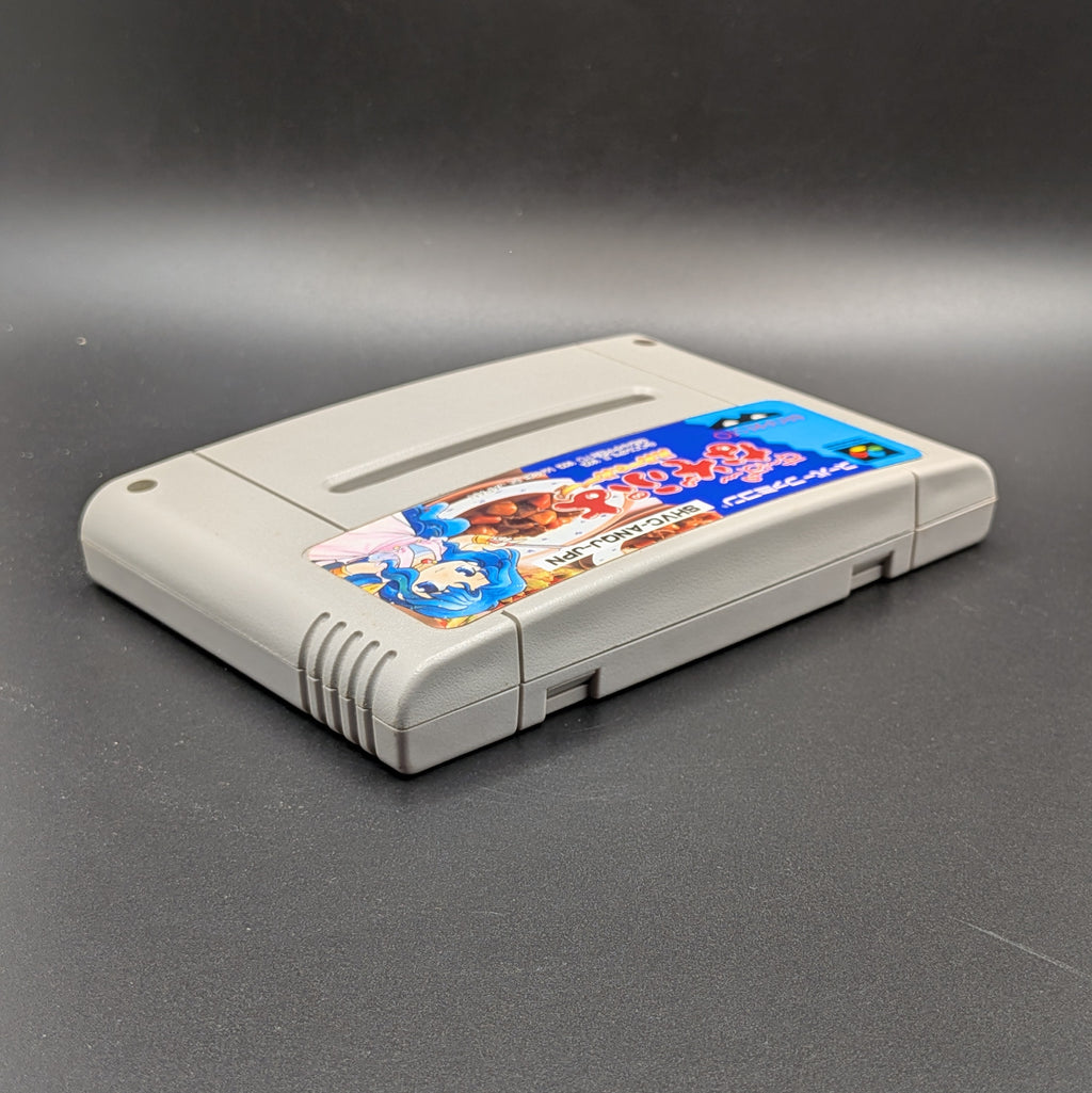 Super Nazo Puyo Rulue no Roux for the  Super Famicom. The SFC Cart is laying on its back, shown at a 3/4 angle to show the front and top of the cart. Pictured on a black background. 