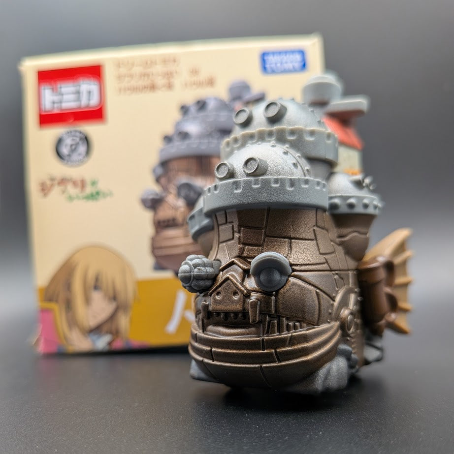 Howls Moving Castle Tomica Dream  Model No.8 - A close up front view with the box behind, on a black background.