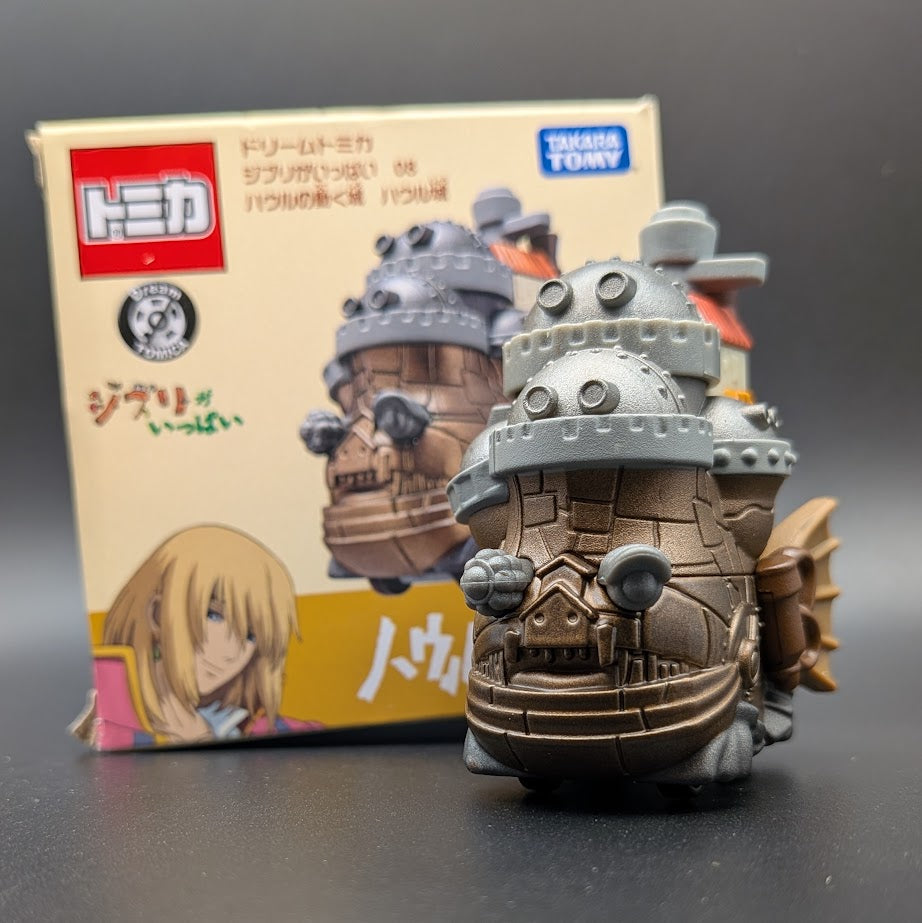 Howls Moving Castle Tomica Dream  Model No.8 - Front View with box behind, on a black background.