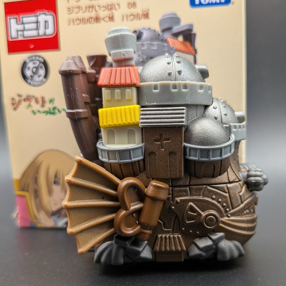 Howls Moving Castle Tomica Dream  Model No.8 - Left side view with the box behind, on a black background.