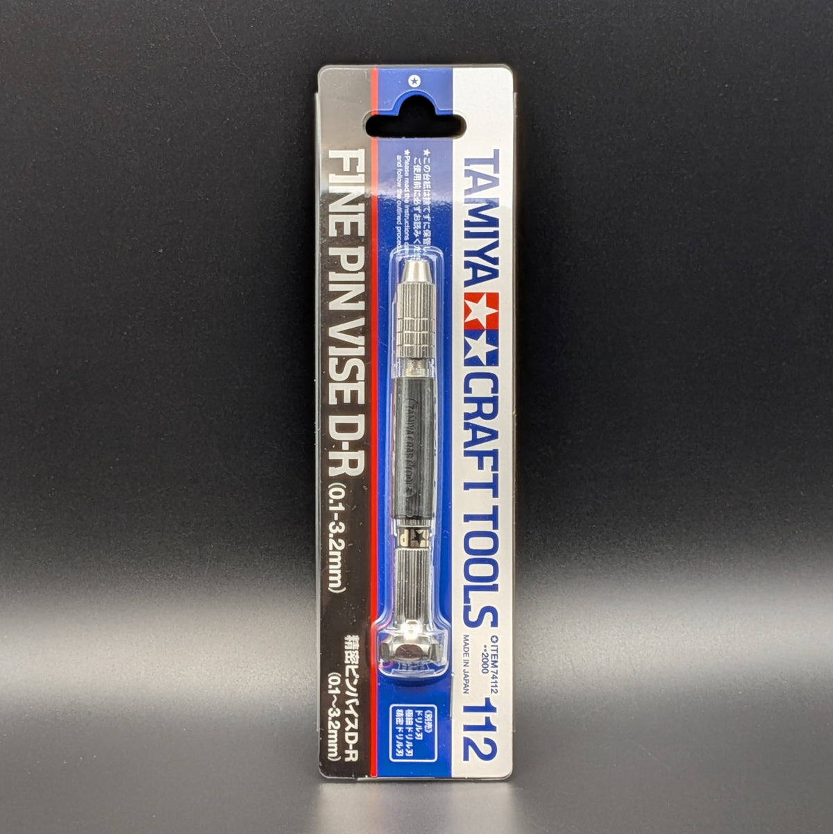 Tamiya 74112 Fine Pin Vise D-R (0.1-3.2mm) in its original blister card packaging and standing up right, displayed on a dark gray background.