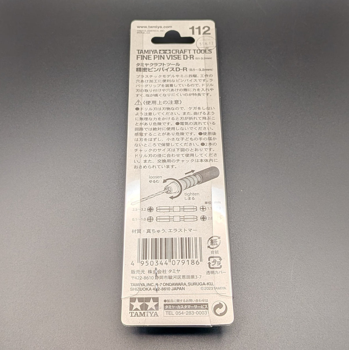 Tamiya 74112 Fine Pin Vise D-R (0.1-3.2mm) in its original blister card packaging, showing the back where information is written in Japanese and displayed on a dark grey background.