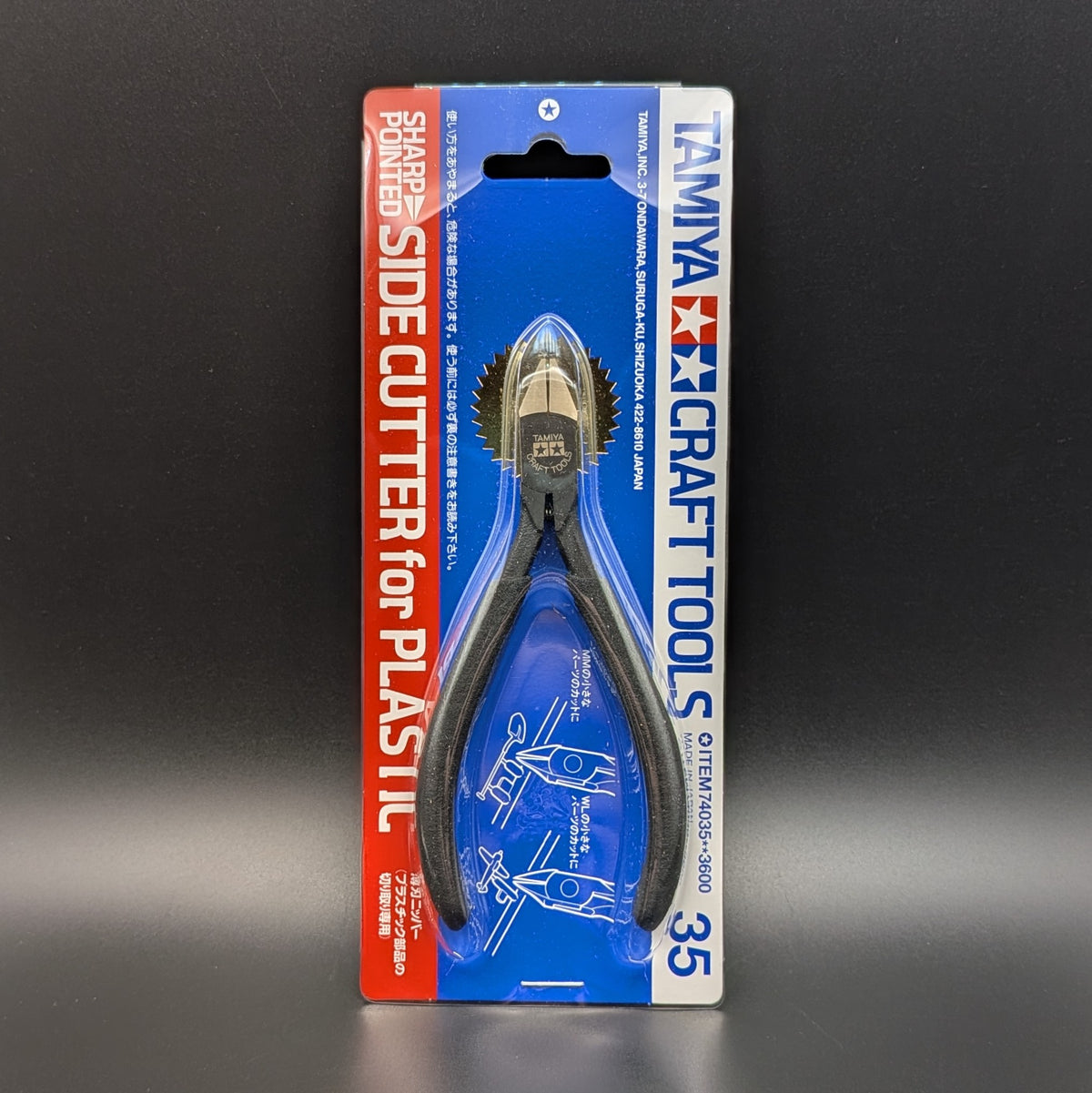 Tamiya Craft Tools Sharp Pointed Side Cutter for Plastic, model 74035 in its original blue and red retail blister packaging, shown standing up right against a dark grey background.