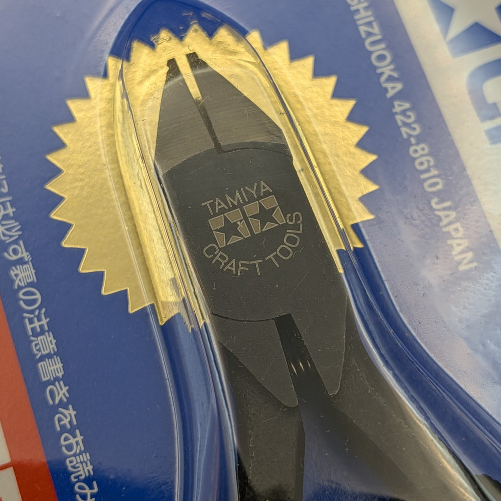 Tamiya Craft Tools sharp pointed side cutters for plastic in black, sealed in clear plastic blister packaging with a blue cardboard backing and gold starburst design.