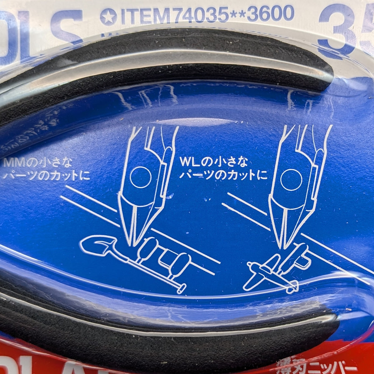 Close-up of a blue plastic packaging insert with white line drawings showing tool usage and Japanese text. Tamiya Craft Tools  sharp pointed side cutters 74035.
