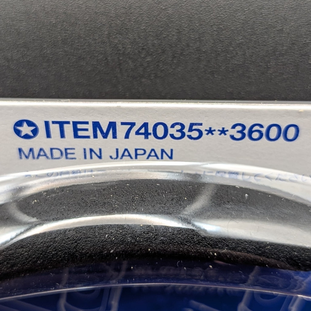 Close-up of a product label reading 'ITEM74035**3600' and 'MADE IN JAPAN' in blue text on a white strip down the side of the packaging, with a black background.