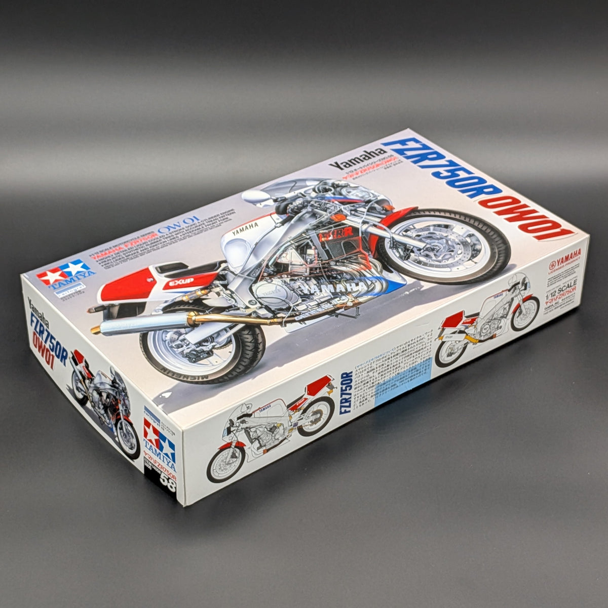 Tamiya Yamaha FZR750R OW01 Superbike 1:12 Plastic Model Kit 14058 displayed on a dark grey background.