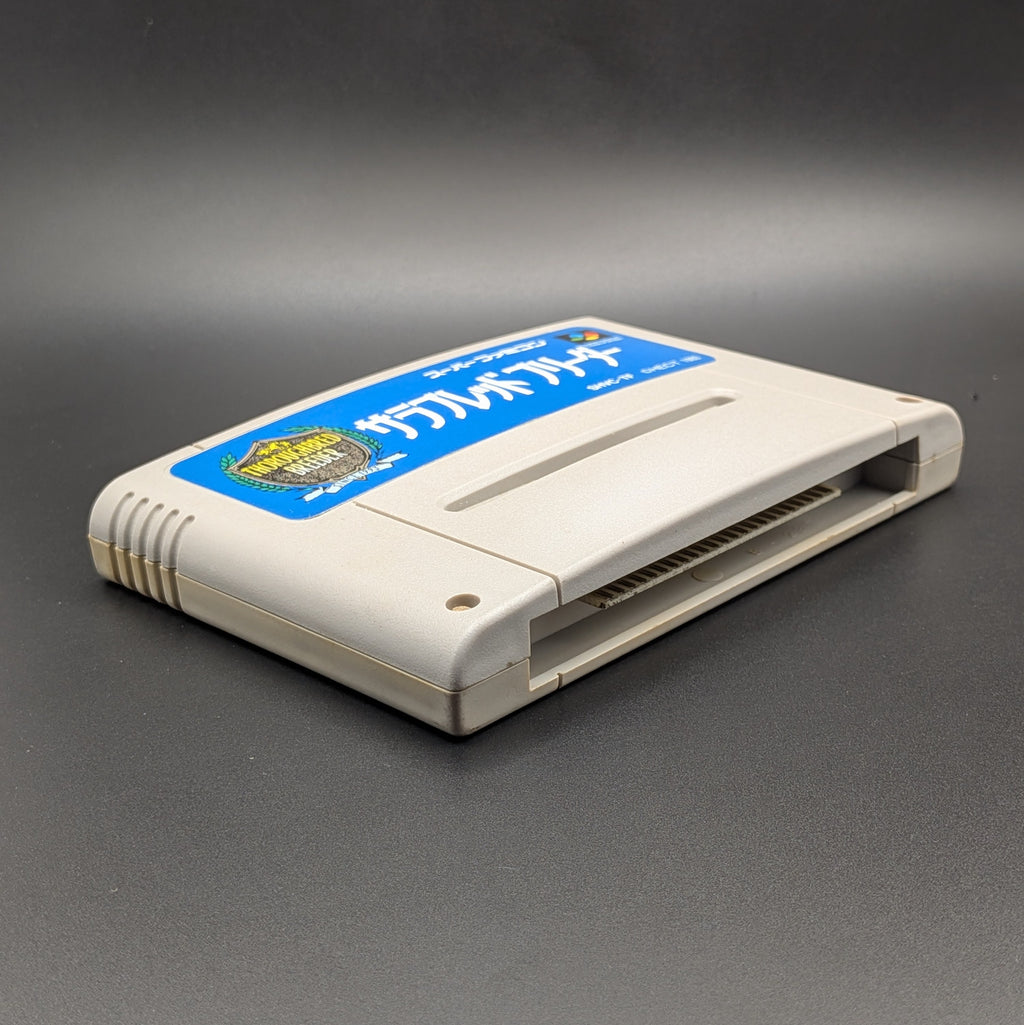 Thoroughbred Breeder video game cartridge for Nintendo's Super Famicom (SFC) Entertainment System, shown laying on its back with the label facing up and the bottom slot is visible. Pictured on a dark grey background.