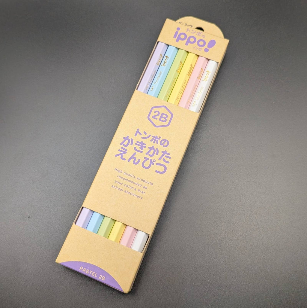 A package of 2B Ippo! multi-color pastel roller pens in a tan cardboard sleeve, photographed on a dark gray surface.