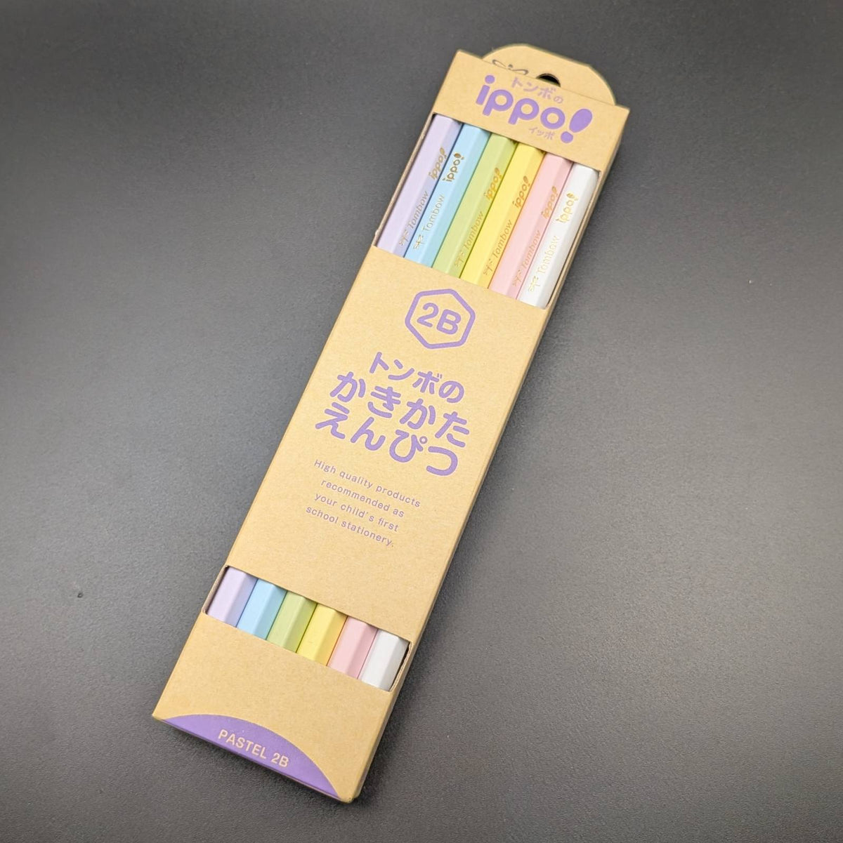 A package of 2B Ippo! multi-color pastel roller pens in a tan cardboard sleeve, photographed on a dark gray surface.