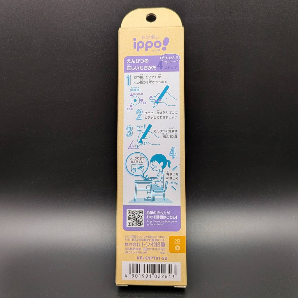 A tall, narrow beige packaging card for the ippo! pencil, photographed against a dark gray gradient background. The card features the 'ippo!' brand logo in purple and white, instructional diagrams in blue showing how to hold and write with the pencil, a QR code, and a barcode at the bottom.