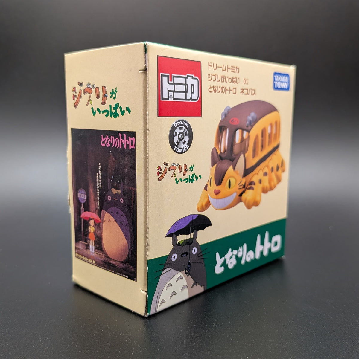 A boxed collectible toy from My Neighbour Totoro , Cat Bus, shown in its original Japanese packaging against a dark gray background.