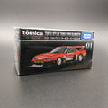 Tomica Premium model car of a Nissan Skyline Turbo Super Silhouette #01 in red and black with Tomica livery. Front facing  at a slight 3/4 angle and on a grey background.