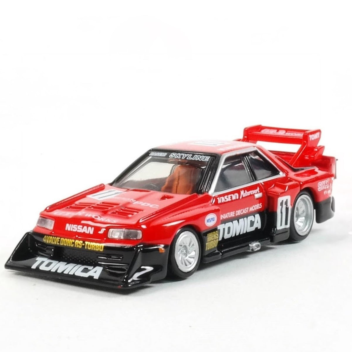 Tomica Premium model car of a Nissan Skyline Turbo Super Silhouette #01 in red and black with Tomica livery out of box. Facing forwards at a 3/4 angle  on a white background.