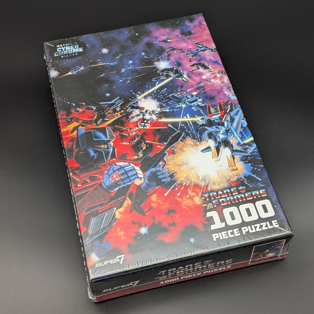 Transformers 1000 Piece Puzzle box by Super7, featuring a dynamic space battle illustration with red and blue robots in a starry galaxy setting.