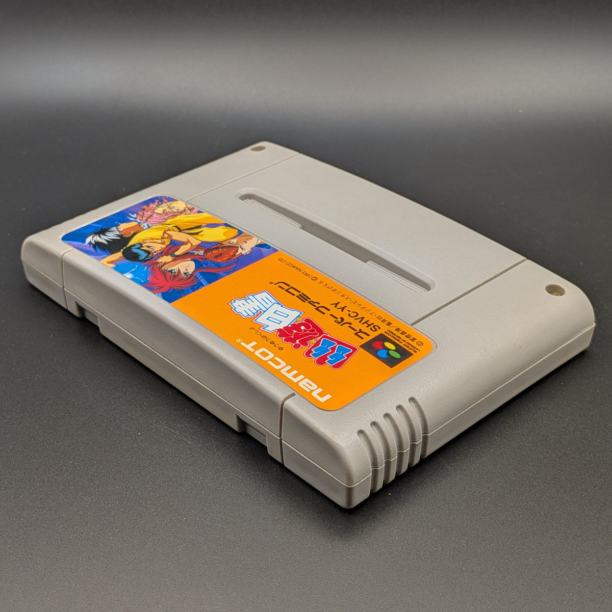 Yu Yu Hakusho video game cartridge for Nintendo's Super Famicom (SFC) Entertainment System, shown laying on its back with the label facing upwards. Showing the left hand side and top edge. It is displayed on a dark grey background.