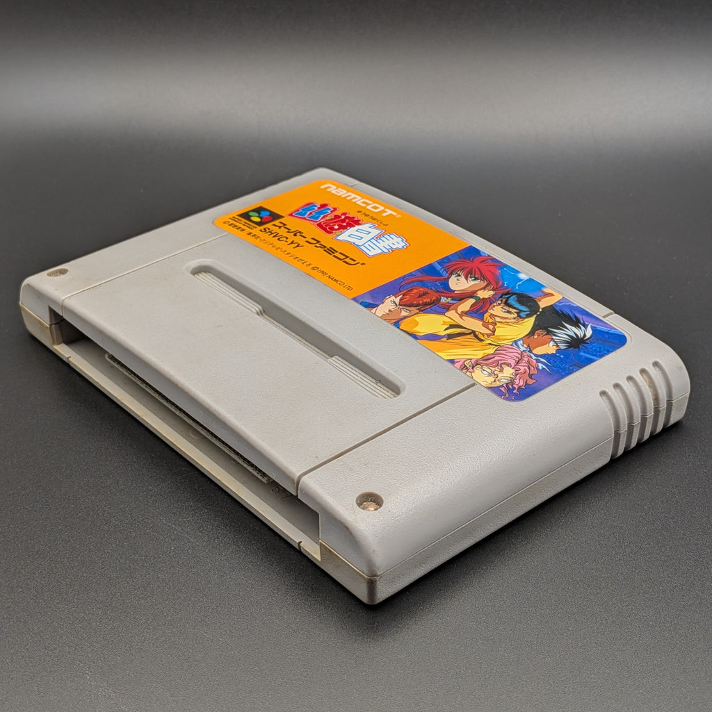 Yu Yu Hakusho video game cartridge for Nintendo's Super Famicom (SFC) Entertainment System, shown laying on its back with the label facing upwards. Showing the right hand side and bottom slot. It is displayed on a dark grey background.