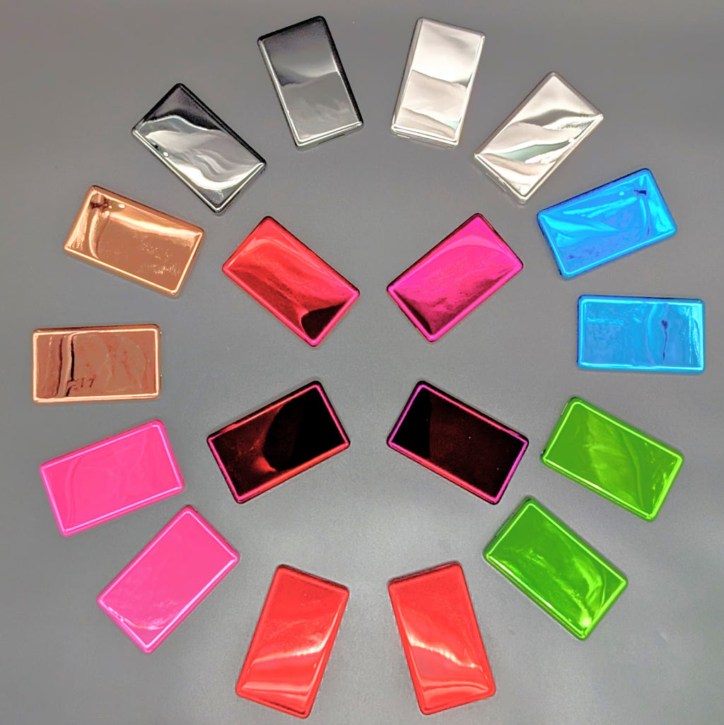 A collection of rectangular metallic iPod back plates in various colors, including pink, red, green, blue, silver, and copper, arranged in a circular pattern on a neutral gray background.